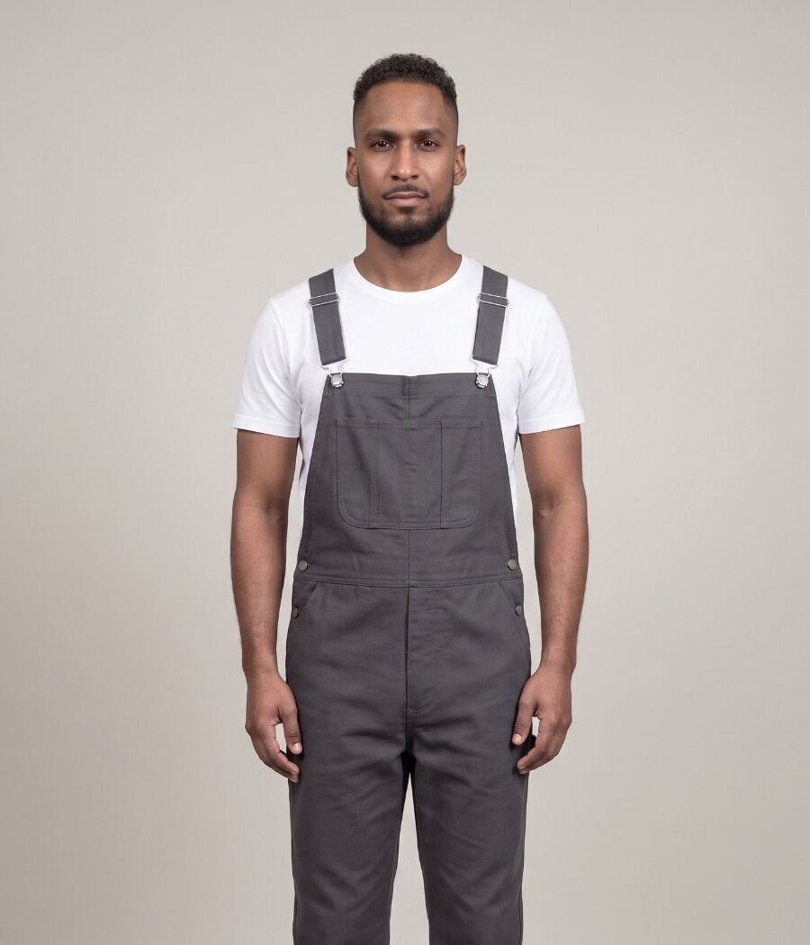 Front view of a man in well-fitted charcoal bib overalls over a white T-shirt, with the bib sitting at mid-chest